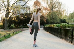 mujer ejercitando estirando piernas