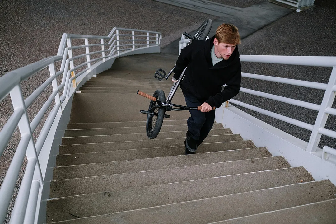 joven subiendo escaleras con bicicleta
